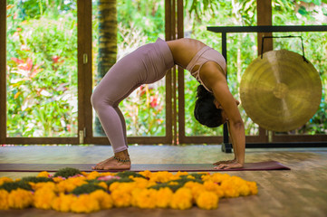young attractive and healthy Asian Indonesian acrobat woman practicing acro yoga exercise in...