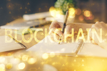 Cryptocurrency hologram, bitcoin, ico theme over hands taking notes background. Concept of blockchain. Multi exposure