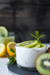 Homemade proteic greek yogurt with kiwi, lemon and mint and healthy shack of kiwi, banana and lemon