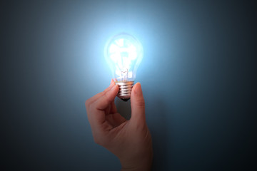 Switched on light bulb on young girl's hand. Concept of having idea, creatiivity and knowledge