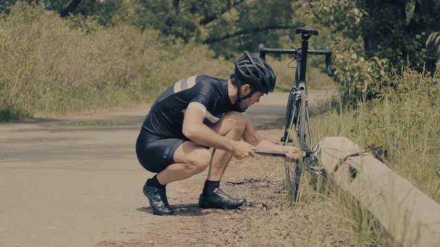 Cyclist Repairing A Bicycle.Bicyclist Pumping Air Into A Bicycle Tire.Athlete Fills Bicycle Tire Using Hand Pump.Cyclist Repairing His Bike.Man Is Inflating With Small Pump Bicycle Tyre.Bike Repair