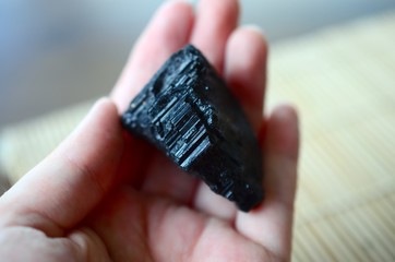 Raw Black Tourmaline Specimen. Schorl being held in hand. Black healing crystal. Ground and protective healing stone. Rough Schorl in woman's hand. Wiccan healing crystals