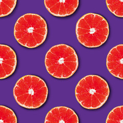 Seamless pattern made of red tangerine on a purple background