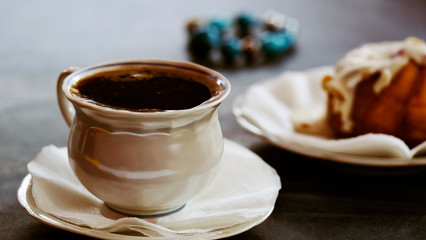 A Cup of coffee and a fresh cake on a saucer. Close up.