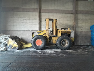 Fototapeta na wymiar Big yellow car loader in the warehouse.