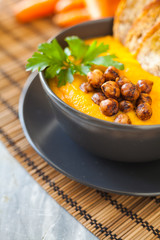 Fresh vegan plate of carrots cream soup with chickpeas