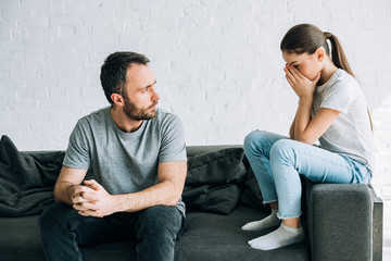 sad daughter and father having conflict at home