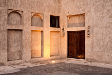 Antique Arabic style building and wooden door in old Dubai