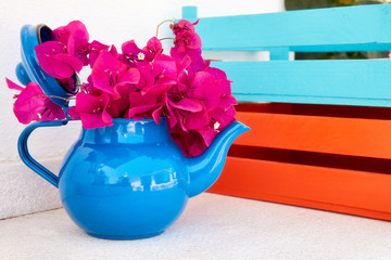 Beautiful fresh red bougainvillea in a decorative teapot used as a flowerpot