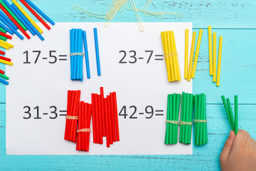 kid doing subtraction equations using counting rods