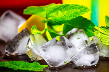 Melting ice cubes with mint leaves and lemon.