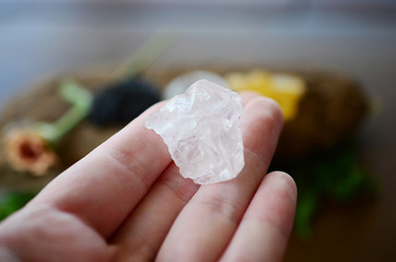 Woman's hand holding clear quartz! Beautiful translucent Quartz specimen, bright colors in natural lighting. Witch holding crystal, Wiccan crystal offerings. Shiny quartz stone being held.