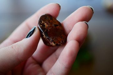 Brecciated Jasper. Tumbled Jasper with Hematite. Healing crystal for Grounding, Mental Clarity, Red Jasper. Witchy healing crystal, beautiful jasper. Natural lighting. Crystal held in woman's hand. 