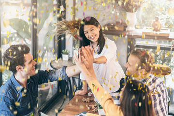 success victory creative meeting with multination coworker partners with hand power and confetti papershoot with happiness and joyful