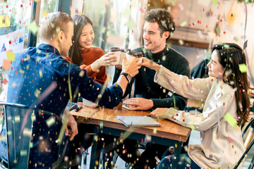 success victory creative meeting with multination coworker partners with hand power and confetti papershoot with happiness and joyful