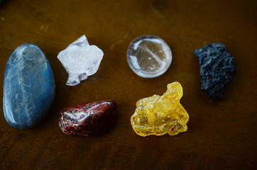 Variety of healing crystals on wooden table. Rose Quartz, Tektite, Labradorite, Brecciated Jasper,...