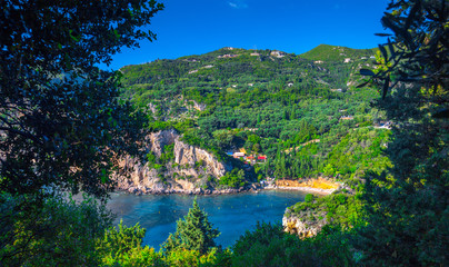 Beautiful summer panoramic seascape. View of Paleokastritsa famous beach in close bay with crystal clear azure water on Corfu island, Ionian archipelago, Greece.