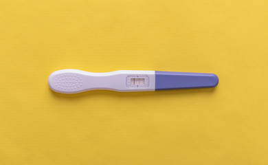 Pregnancy test on yellow background.