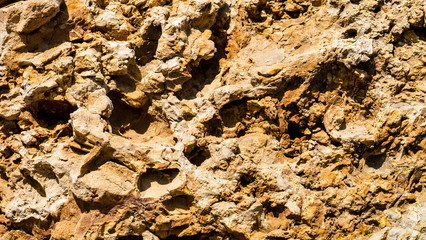 Highly textured and pitted sandstone type rock background from Seaham Beach in County Durham England.  Image taken on a sunny and bright day.