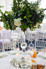 Elegant wedding table setting with white flowers and glass decorations