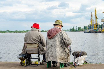 Fishermen in bright hats on the bank of the river