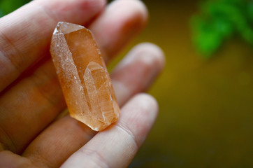 Woman's hand holding tangerine quartz points. Orange Quartz points shot in natural lighting. Orange...