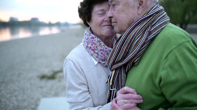 Senior couple in love dancing at riverside during sunset