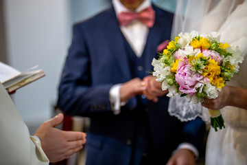 Bouquet of flowers in the hand of the bride during the marriage ceremony