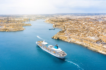 Fototapeta na wymiar Aerial height view of Malta Valletta and Birgu, floating sailing passanger cruise liner ship to the Great Bay.