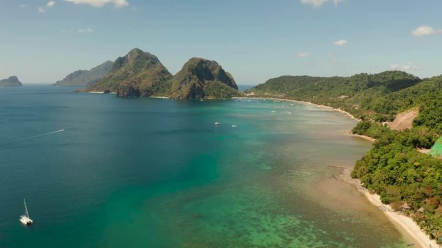 Aerial drone of tropical beach on background of mountains. Seascape with sea, sand, palm trees. Corong corong beach, El Nido, Palawan, Philippines. Summer and travel vacation concept