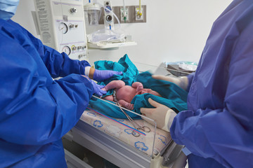 Doctors checking newborn baby