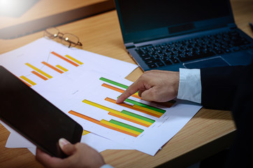 Businessmen are analyzing stock market trading of the stock market on his desk