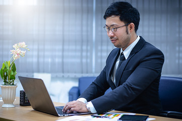 Businessman sitting with a laptop in his office