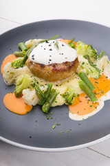Beef cutlet served with mashed potatoes, broccoli and cauliflower