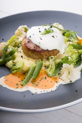 Beef cutlet served with mashed potatoes, broccoli and cauliflower