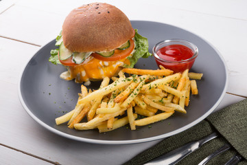 Burger served with french fries and ketchup