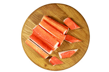 Crab sticks on wooden cutting board isolated on white background © olyasolodenko
