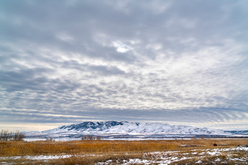 Dramatic sky filled with cottony clouds over a scenic landscape in winter