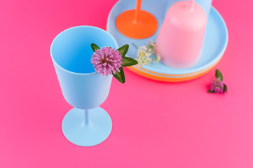 Plastic dishes bright colors for a picnic. Pink and blue colors on the photo. Eco plastic. Copy space.