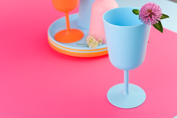 Plastic dishes bright colors for a picnic. Pink and blue colors on the photo. Eco plastic. Copy space.