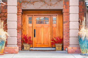 Fototapeta na wymiar Brown wooden front door with decorative glass panels at the entrance of a home