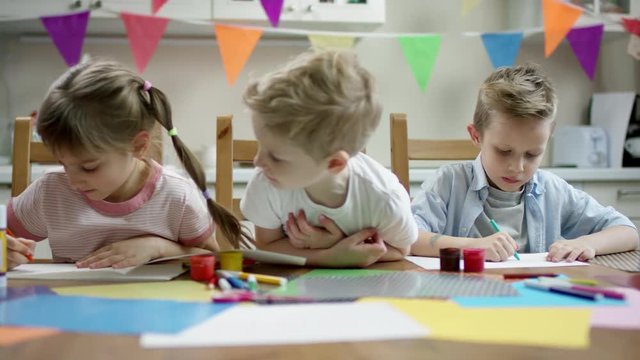 children do craft things with scissors and pens with flow camera and focus on them