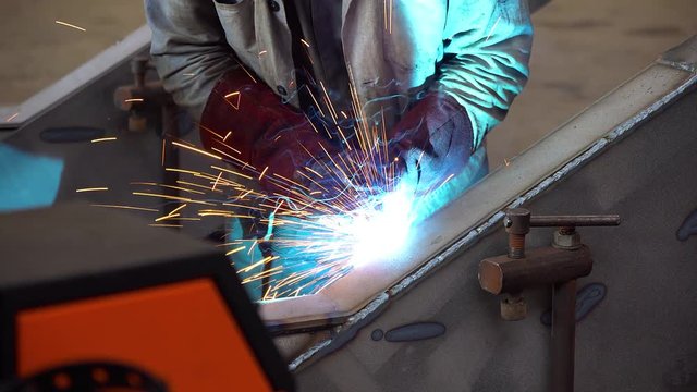 worker conducts welding work, Welder at work in factory, Welder welding a metal in workshop