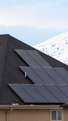 Clear Vertical Solar panels installed on the dark roof of a home with snow in winter