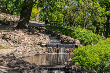 Fototapeta na wymiar Small Water Cascade In The City Park.