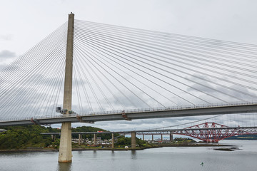 The new Queensferry Crossing bridge over the Firth of Forth with the older Forth Road bridge and the iconic Forth Rail Bridge in Edinburgh Scotland.