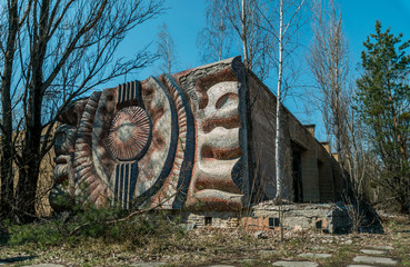 Street of the abandoned ghost town Pripyat. Overgrown trees and collapsing houses in the exclusion...