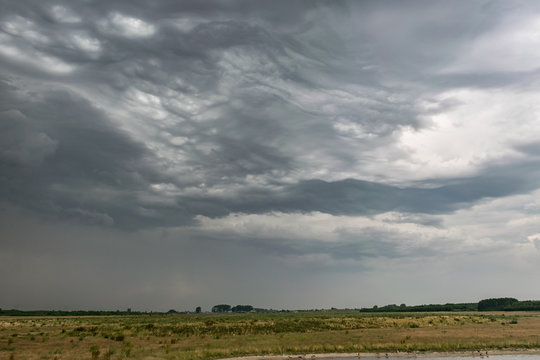 Thunderstorm with dramatic appearance over the flat, wide open countryside near the city of Leiden, Holland. These clouds are called Asperitas and are caused by trapped gravity waves in the atmosphere