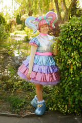 cute girl animator in a unicorn costume in the park on the green grass