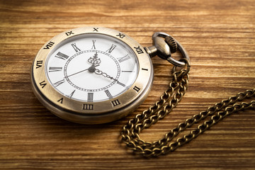 Vintage pocket watch clock on wooden background